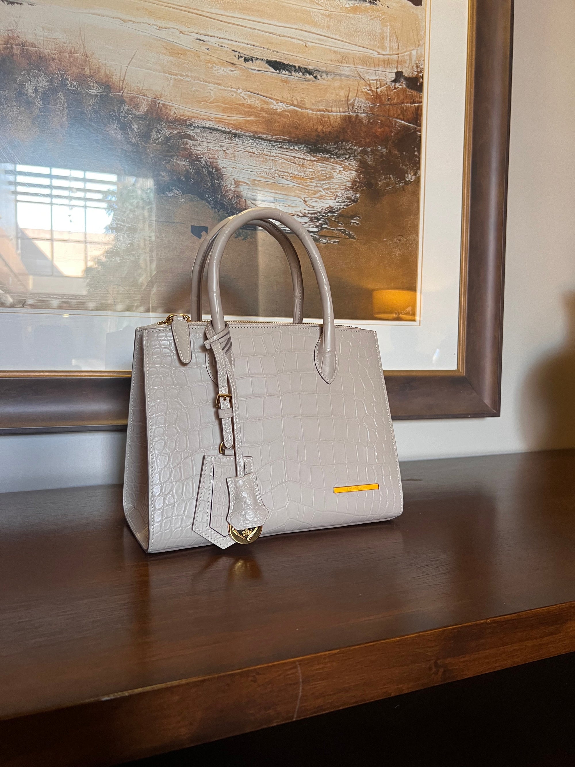 A beige or ivory color small tote real crocodile handbag